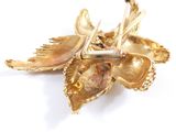 a close up of a gold brooch with spoons and spoons on it