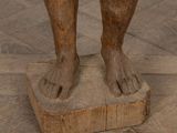 a statue of a person standing on a wooden block