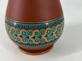 an image of a brown pitcher with blue and green designs