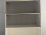a white bookcase that is in the middle of a room