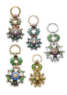 un ensemble de quatre objets métalliques de couleurs différentes posés sur une surface blanche