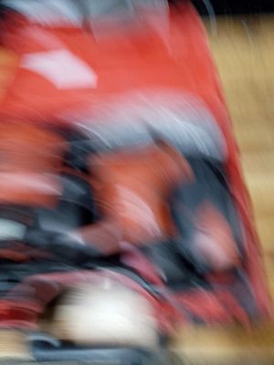 blurry photograph of a person riding a red motorcycle on a wooden floor