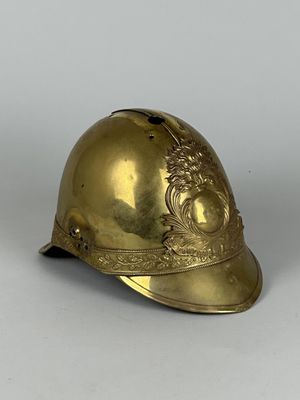 un vieux casque en laiton orné d'un motif floral sur le côté