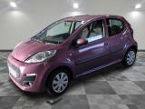 La petite voiture violette est garée sur un sol en carrelage à damier.