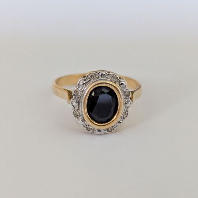 gros plan d'une bague en or avec une pierre noire