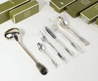 beaucoup de couverts sur une table où se trouvent des boîtes et des cuillères