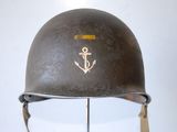 a helmet with an anchor on it sitting on a stand