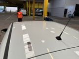 a man standing next to a white car in a warehouse