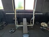 une salle de sport avec un banc, des poids et d'autres équipements