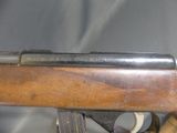the rifle is sitting on top of a wooden stand on a gray background