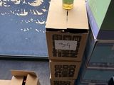 a bottle of wine sitting on top of a cardboard box next to a cardboard box