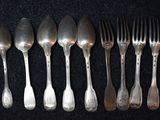 five spoons and six forks on a black surface