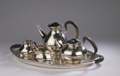 a silver tea set on a silver tray on a table