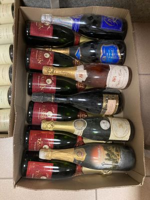 plusieurs bouteilles de vin dans un carton posé sur le sol