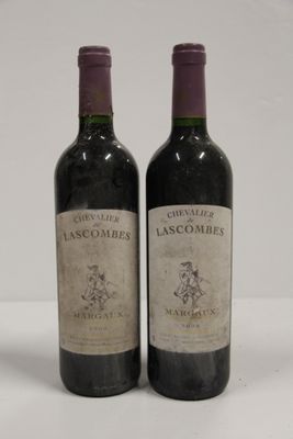 two bottles of red wine sitting next to each other on a table