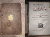 an old book sitting on top of a wooden table next to another book
