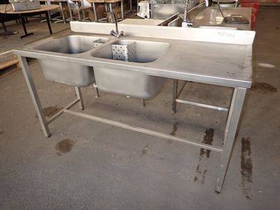 deux éviers au milieu d'une grande pièce équipée de tables et de chaises