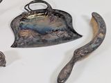 a silver plate with a spoon and a spoon rest on it