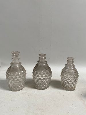 trois vases en verre transparent posés sur un comptoir blanc