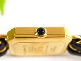 an image of a close up of a gold wrist watch with a black bead
