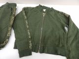 green jacket with zippered sleeves and zippered cuffs on a white surface