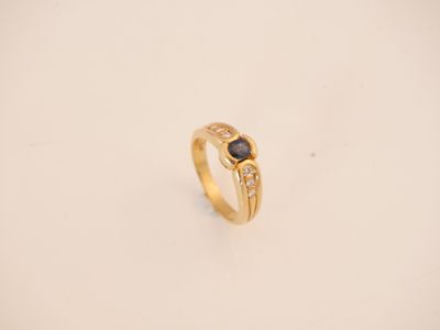 AUGIS. Bague centrée d’un saphir ovale facettée en serti dem…