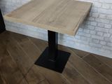 the table is made of wood and has a black metal base