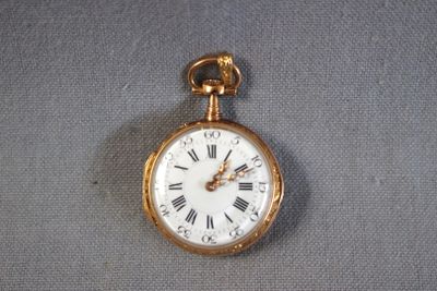 a gold pocket watch with roman numerals on it