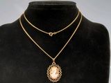 a gold necklace with a pearl pendant on a mannequin neck