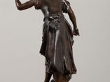 bronze statue of a woman with a basket of flowers on her head