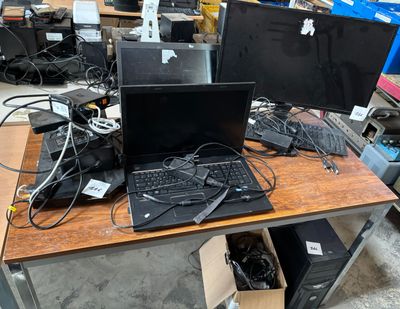 a desk with two computers and a keyboard on it