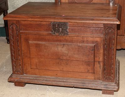un coffre en bois posé par terre à côté d'une commode