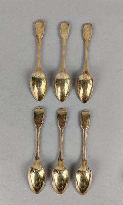 six gold spoons and two silver spoons on a white surface