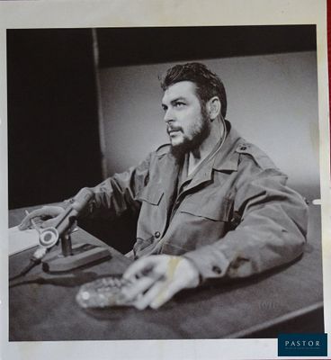 photographie en noir et blanc d'un homme assis à une table avec un appareil photo