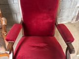 une chaise rouge assise dans une pièce à côté d'un mur de briques