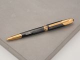 a black and gold pen sitting on top of a piece of paper
