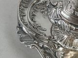a silver plate with a silver tea pot on it