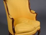 a yellow chair sitting on top of a wooden floor next to a gray wall