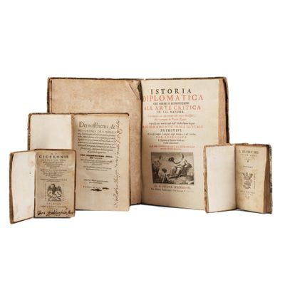 several old books are stacked on top of each other on a white surface