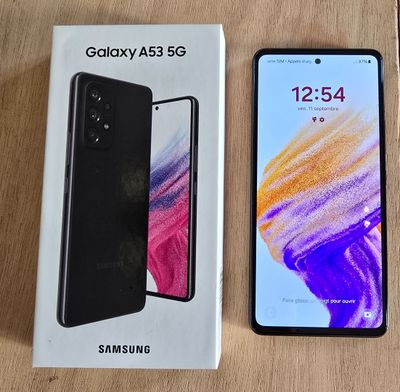 Samsung Galaxy A525s avec sa boîte et son emballage, posé sur une table en bois