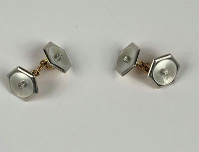 paire de boutons de manchette en argent sertis de diamants sur fond blanc