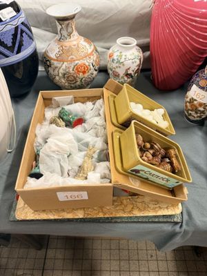 une table sur laquelle sont posés de nombreux vases et autres objets