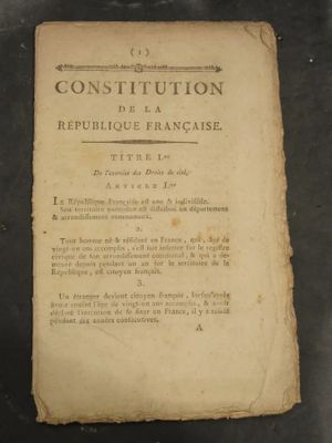 un vieux livre posé sur une table à côté d'une table noire