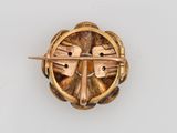 an image of a gold broochle with a cross on it