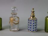 four different colored glass bottles are lined up on a white surface