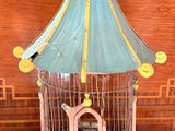 a bird cage with a bird inside of it on a table