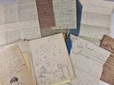 a pile of old letters and papers sitting on a table