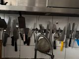 beaucoup de couteaux accrochés au mur de la cuisine