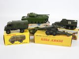 Plusieurs véhicules militaires miniatures sont posés sur des cartons, sur une surface blanche.