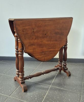 an old wooden table with turned legs on a tiled floor